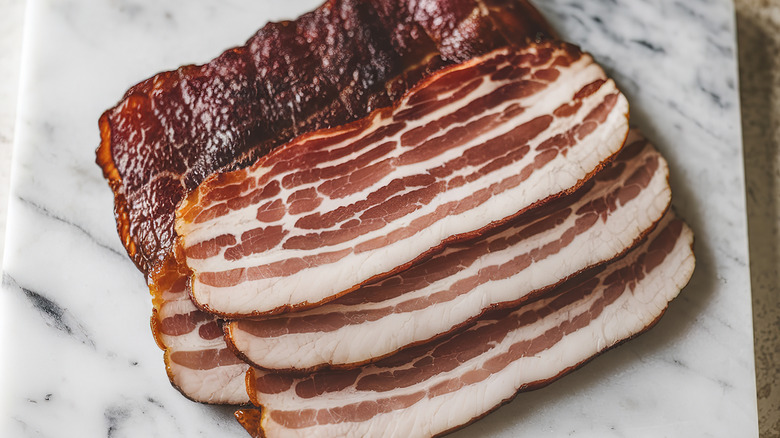 Thick slices of bacon arranged on a marble board