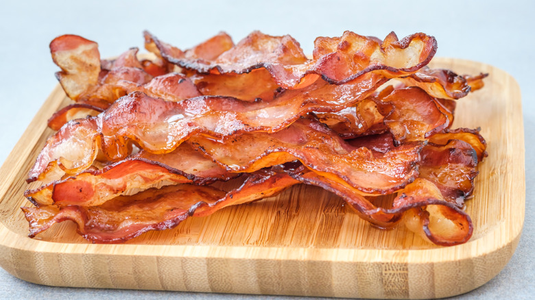 Cooked bacon strips on a wooden board