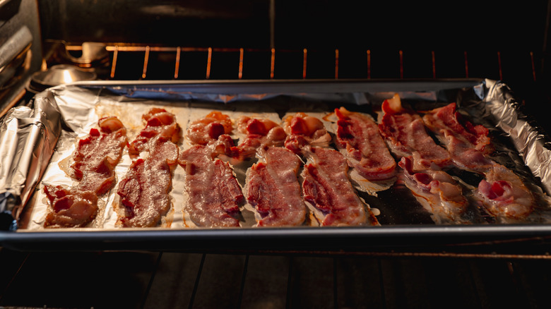 Tray of bacon, cooking in an oven