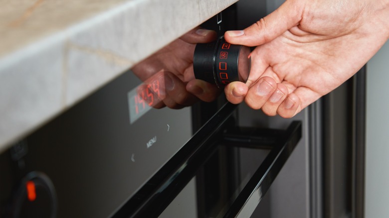 Person turning oven knob