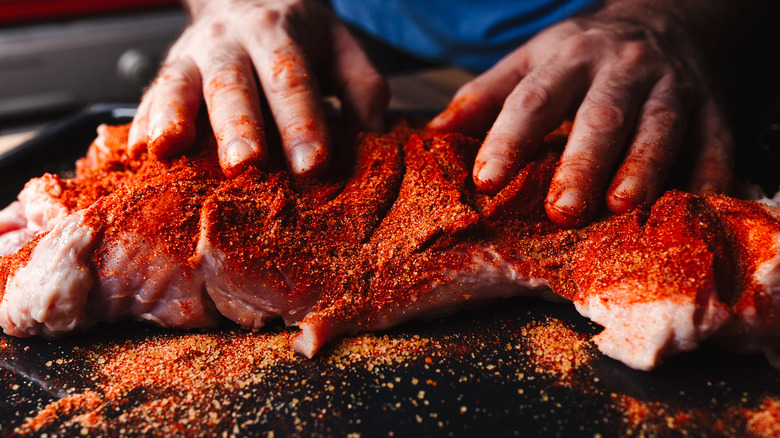 Person rubbing spice into meat