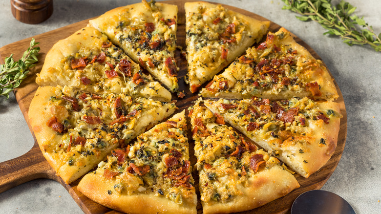 Homemade new haven-style clam and bacon pizza on a wood paddle