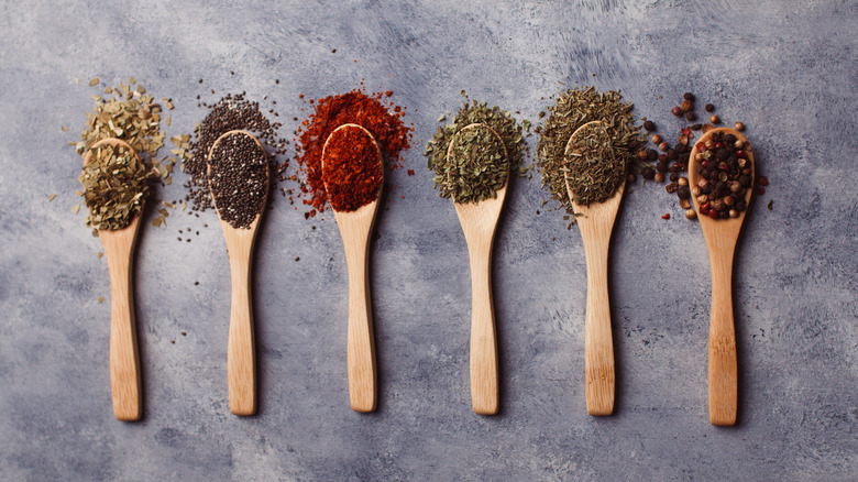 Top view of wooden spoons with various herb and spice blends