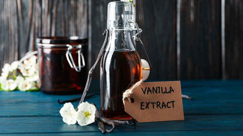 Glass bottle of vanilla extract on a blue wood surface