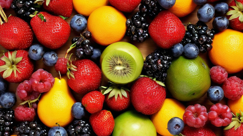 Various fruit and berries arranged on a wooden table up close