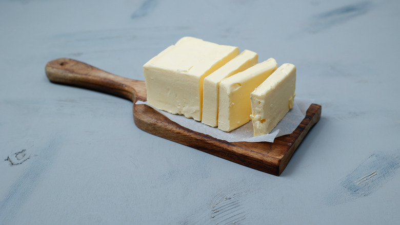 Butter with some slices cut on a small wooden board