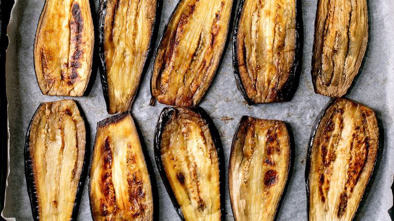 Roasted eggplant halves on a tray lined with parchment paper