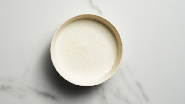 Heavy cream in a bowl on a marble table