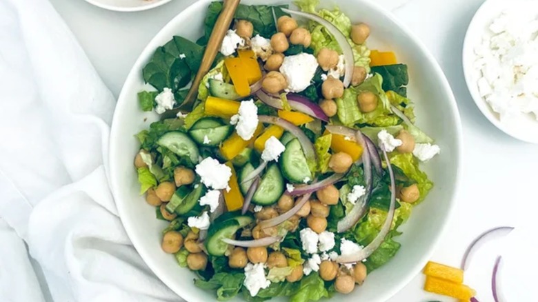 bowl of greek salad with chickpeas, fork
