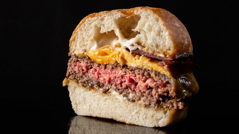 Medium-rare cheeseburger, sliced down the middle