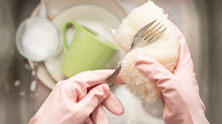 Person washing a fork over the sink