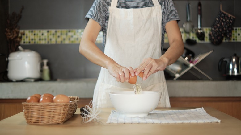 Person cracking an egg into a bowl