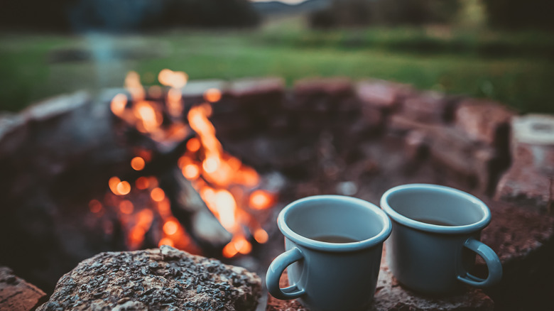 Coffee mugs in front of a campfire 