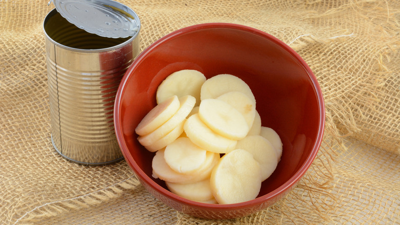 Bowl of rinsed slices of canned potatoes, with empty can next to it