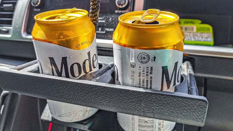 Two cans of Modelo beer sit in a can holder