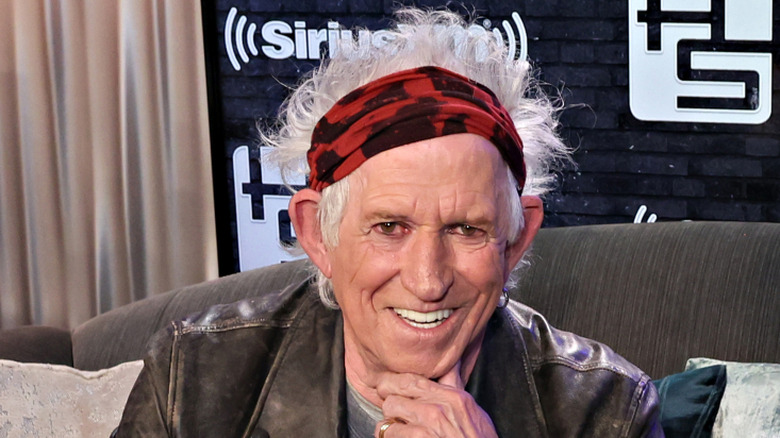 Keith Richards wearing a red and black headband and leather jacket