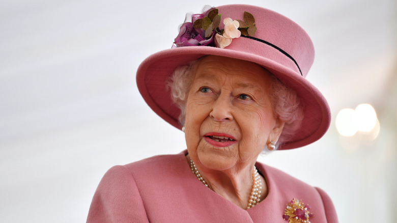 Queen Elizabeth II wearing a ping hat and dress