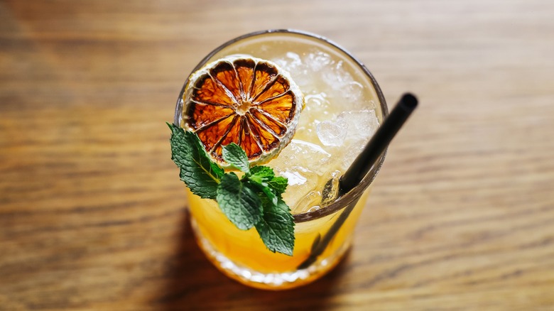 Whiskey sour with a dried orange and mint garnish