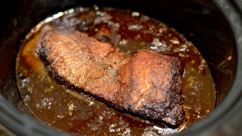 Piece of beef sitting in slow cooker