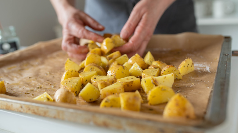 Chef preparing potatoes on a sheet pan