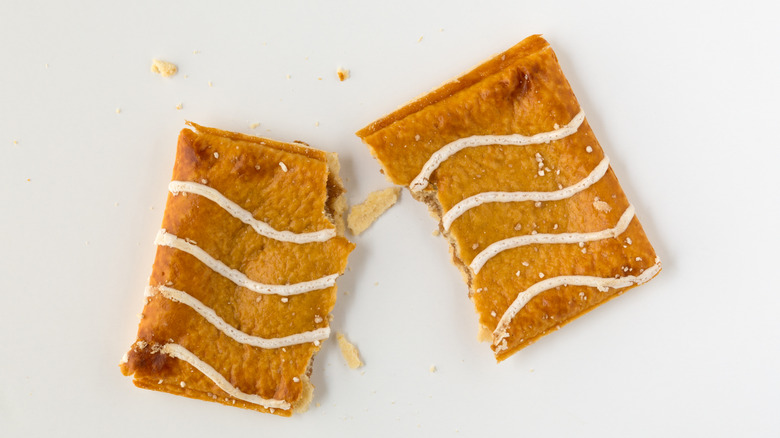 Overhead view of a Pop-Tart with wavy white icing, broken in two
