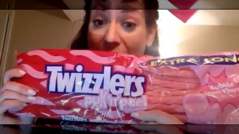 A woman holds a package of Extra Long Bubble Gum Pull 'n' Peel Twizzlers