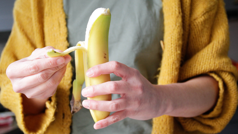 Person peeling a banana