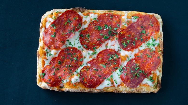 Pizza al taglio, with salami and chopped parsley