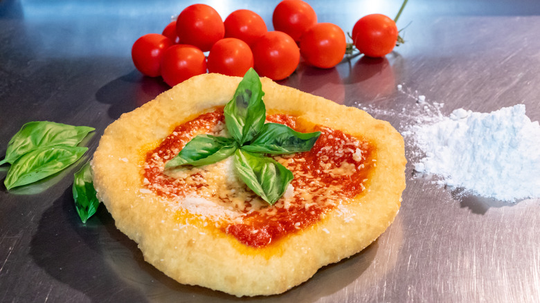 Pizza fritta, with fresh ingredients sitting around it