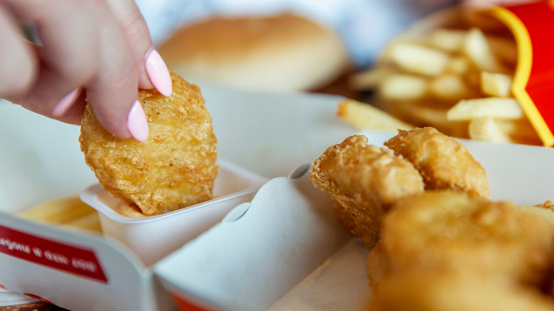 Hand dipping McDonald's chicken McNuggets