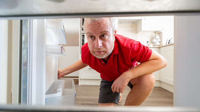 man looking into freezer