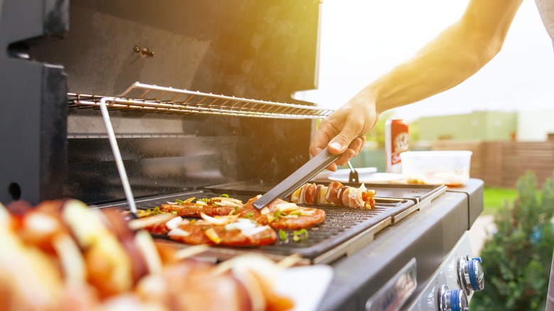 person cooking on gas grill