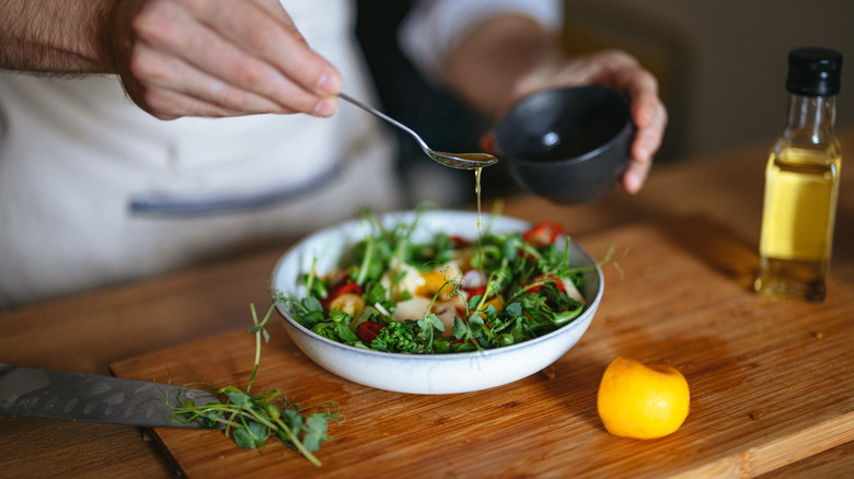 drizzling dressing on salad