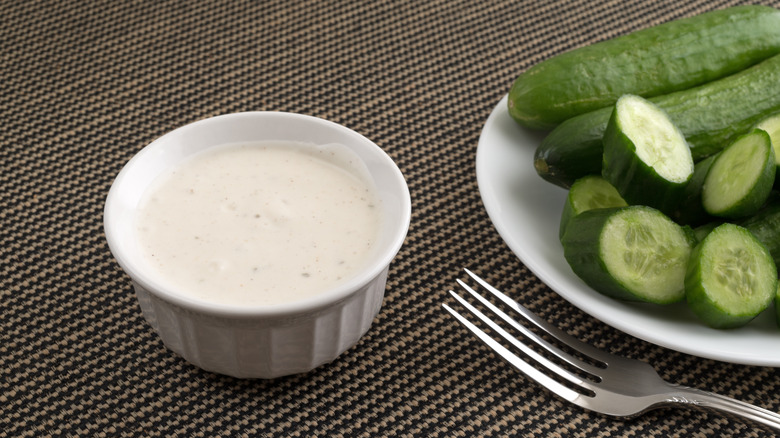 fork and cucumber near dressing