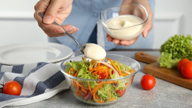 adding dressing to salad