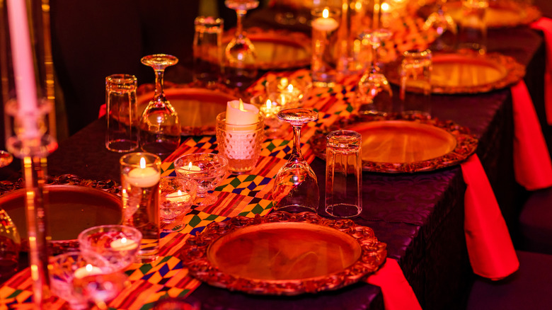 Red and gold themed place settings on a long dinner table