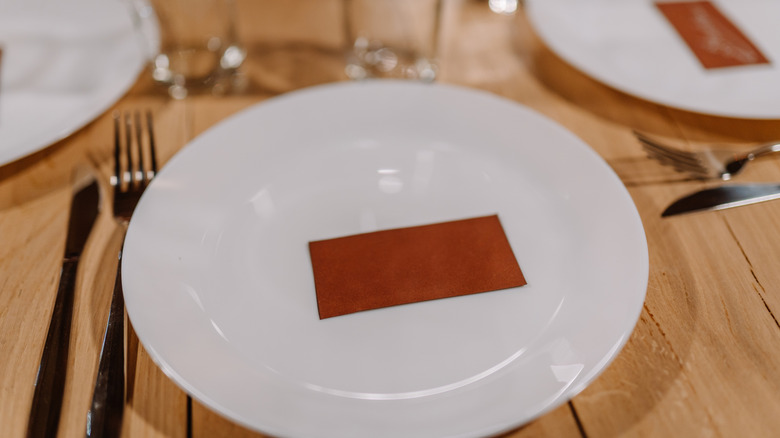 A white plate with a brown placecard on it