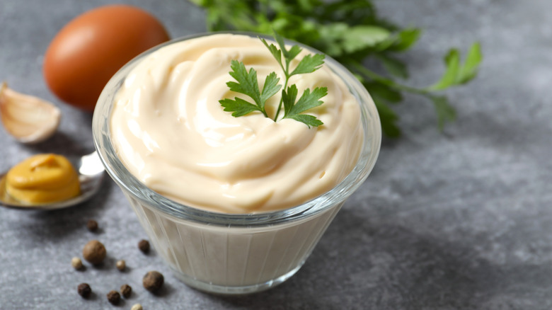 Glass bowl with mayonnaise and its ingredients