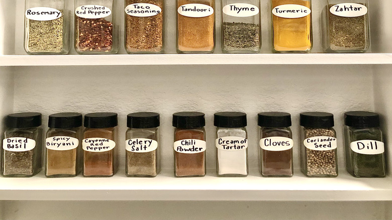 Spices in glass jars lined up on a shelf