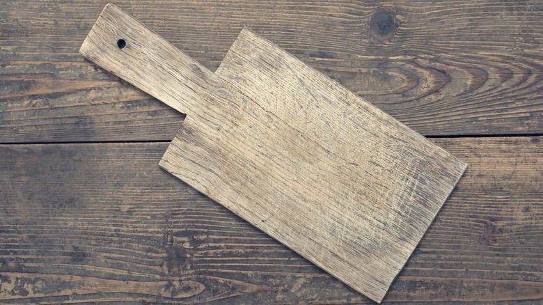 Old wooden cutting board on a wooden table