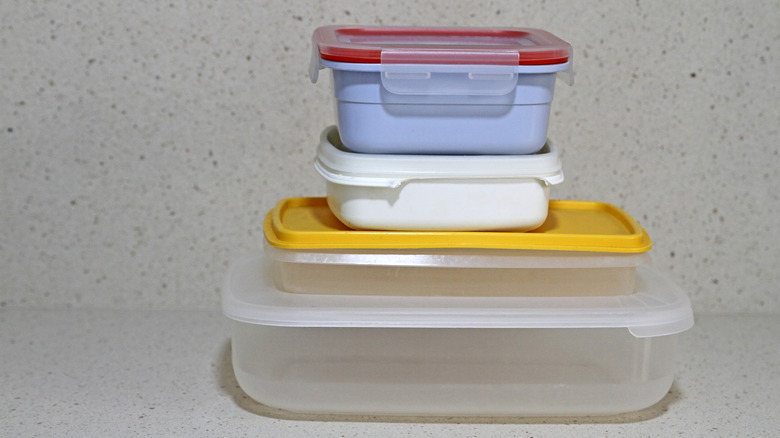 Old food storage containers neatly stacked on a counter