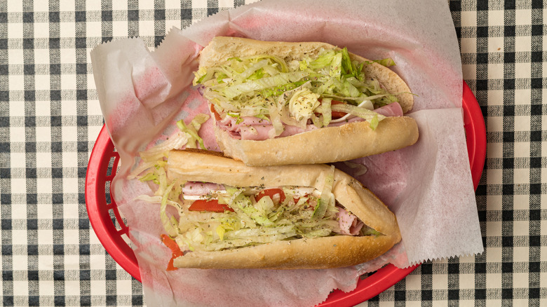 Italian sub in red basket on black and white checkered table
