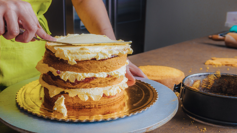 person assembling layer cake