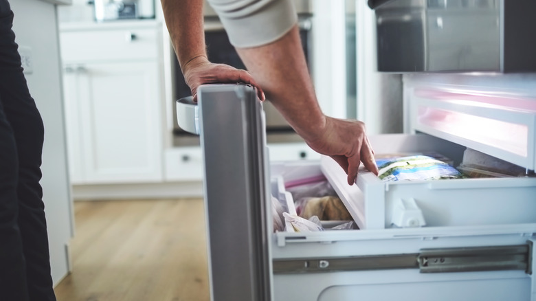 person opening freezer door