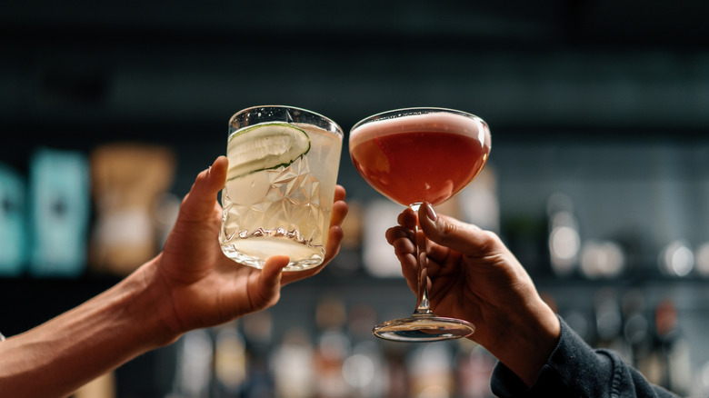 Two people toasting with cocktails