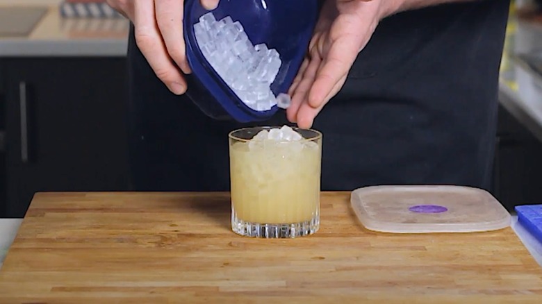 A bartender pours ice into a Tia Mia cocktail