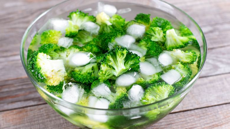 Blanched broccoli in bowl of ice water