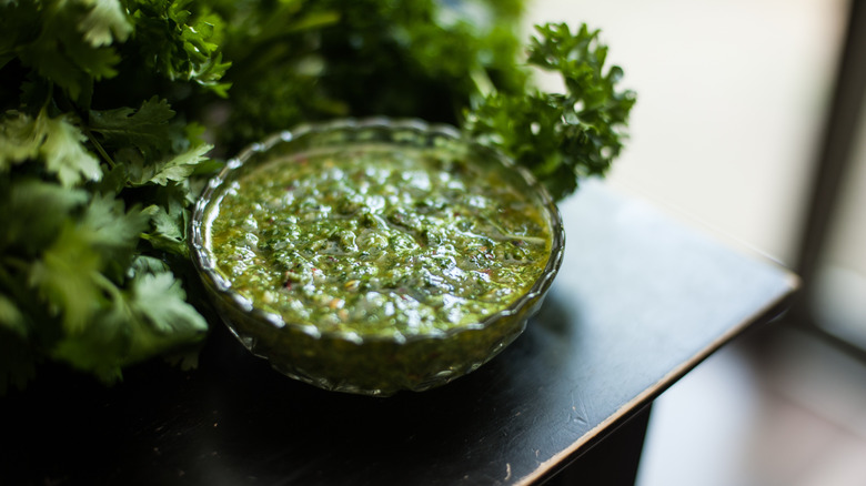 Bowl of chimichurri on black table