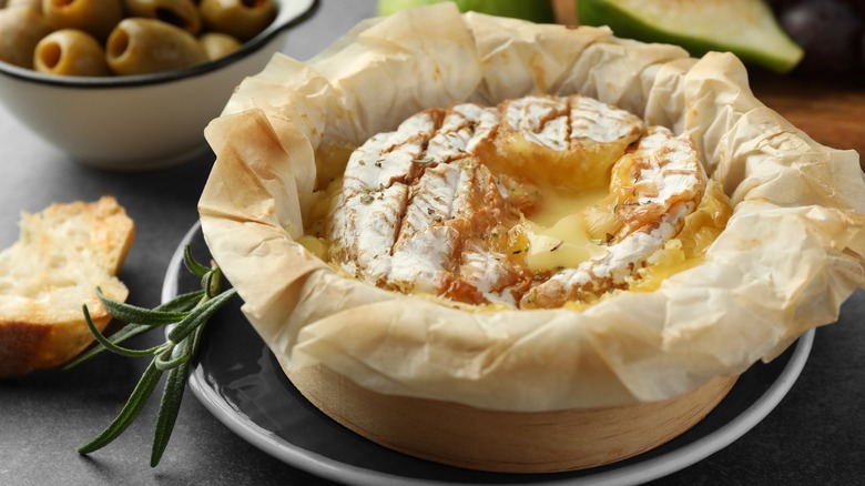 Baked brie with bread, herbs, and olives