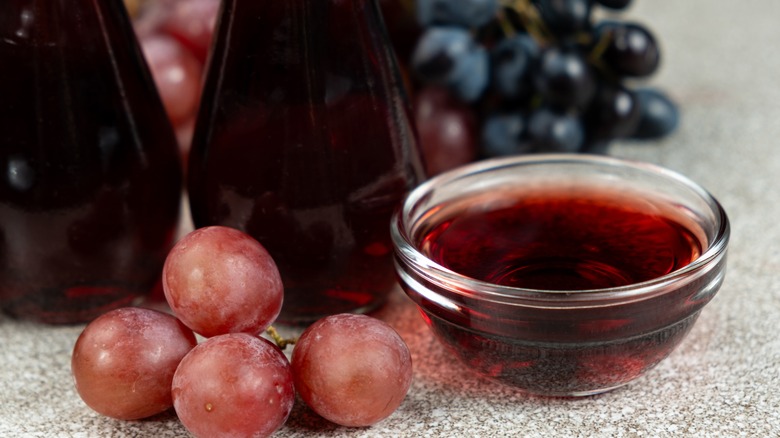 Red wine vinegar in glass bowl, with grapes